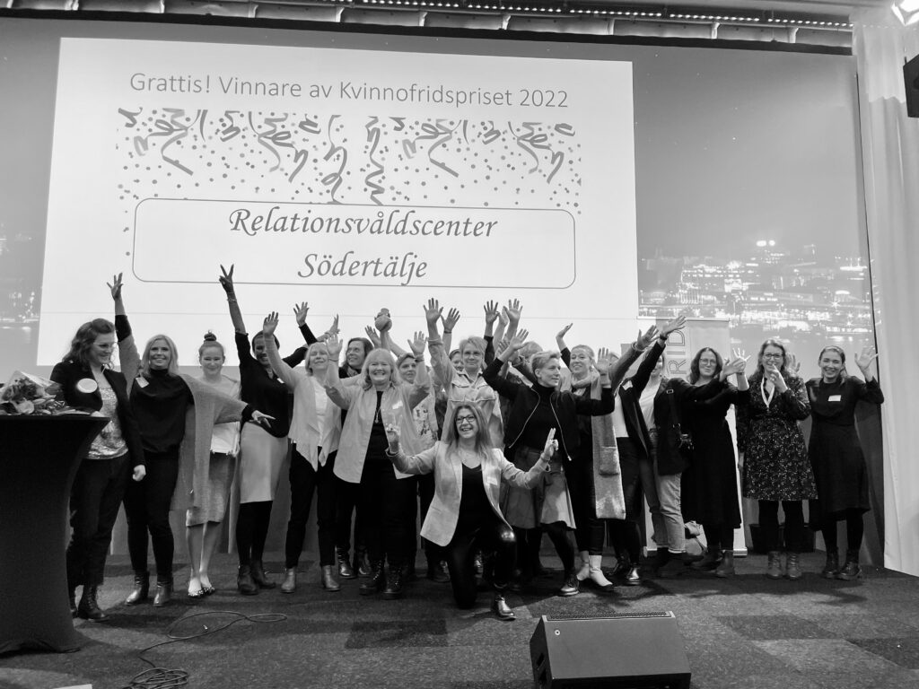 Ett svartvitt foto på personalen i Relationsvåldscenter i Södertälje på scenen vid prisutdelningen.